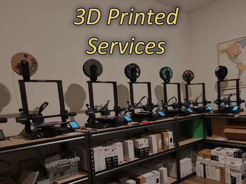 May include: A row of black 3D printers on a metal shelf with a sign that reads "3D Printed Services".