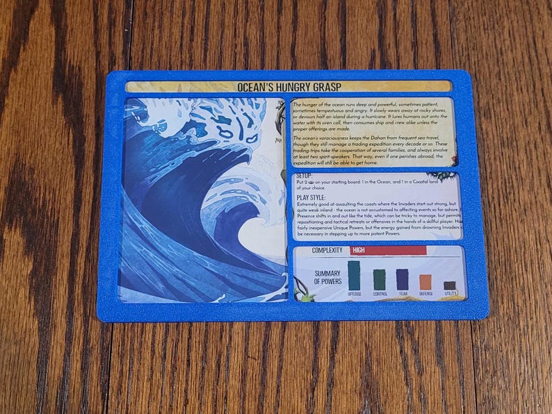May include: A blue-bordered game card titled "Ocean's Hungry Grasp" with text and a graphic of a large ocean wave. The card includes sections for setup, play style, and a summary of powers. The complexity is marked as high.