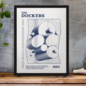 Può includere: Poster incorniciato con la scritta "THE DOCKERS" in blu navy. Il poster presenta un design astratto di cilindri e sfere su una griglia, con testo aggiuntivo tra cui "COLD BLOW LANE SATURDAY 3PM" e "1885".