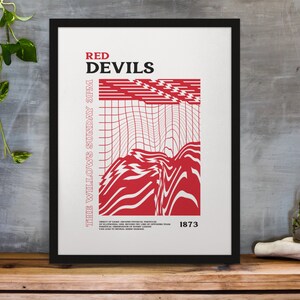 May include: A framed poster featuring the words "RED DEVILS" in red, with an abstract red and white design. The text "THE WILLOWS SUNDAY 3PM" is on the left. The year "1873" is at the bottom of the poster.