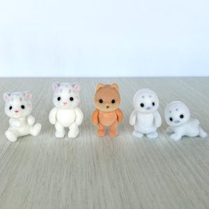 May include: A white ceramic mug with a black handle and the text "But First, Coffee" in a handwritten style. The mug is on a white surface. The mug is 4 inches tall.