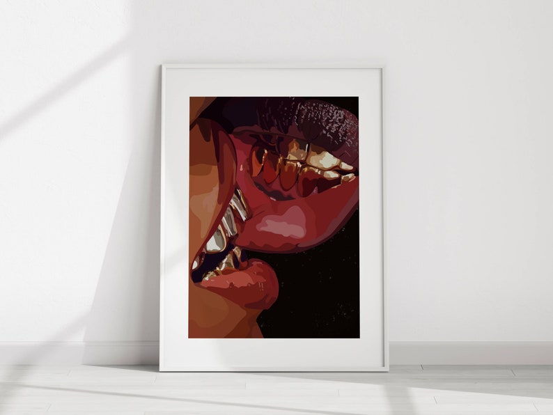 May include: A framed art print featuring a close-up of two sets of lips in a kiss. The lips are a deep red, with gold teeth visible. The artwork is set against a black background.