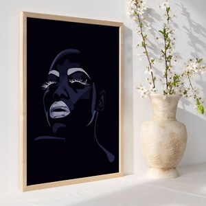 May include: A framed black and white illustration of a woman's face with closed eyes and dramatic makeup. The woman's face is in profile and her lips are slightly parted. The background is black.