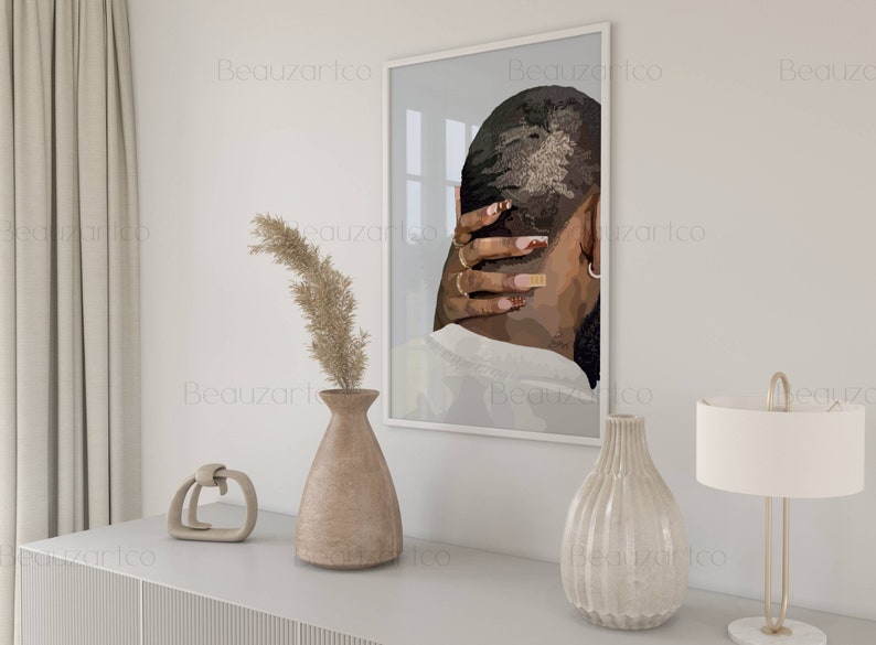 May include: A framed print of a black and white illustration of a person with their hand on the back of their head. The print is in a white frame and is hanging on a white wall.