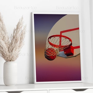 May include: A basketball going through a hoop with a red rim and net. The background is a gradient of purple, pink, and orange.