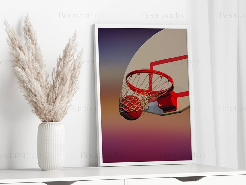May include: A basketball going through a hoop with a red rim and net. The background is a gradient of purple, pink, and orange.