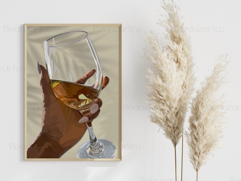 May include: A hand holding a glass of wine. The glass is filled with a golden liquid and the hand is brown. The background is a light beige color.