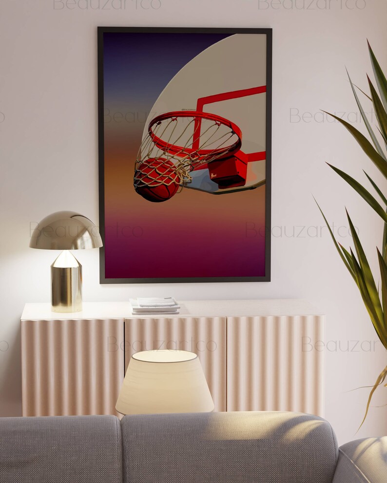 May include: A framed print of a basketball going through a hoop. The basketball is orange and the hoop is red. The background is a gradient of purple, pink, and orange.