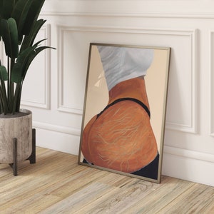 May include: A framed print of a painting depicting a person's lower body with detailed lines and a black thong. The background is a light beige color.