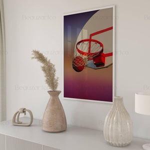 May include: A framed print of a basketball going through a hoop. The background is a gradient of purple, pink, and orange. The hoop is red and white. The basketball is orange and brown.