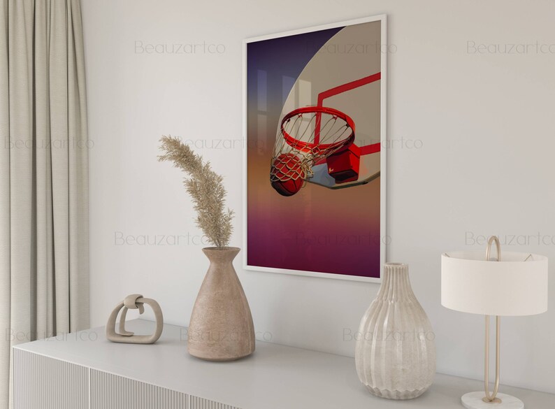 May include: A framed print of a basketball going through a hoop. The background is a gradient of purple, pink, and orange. The hoop is red and white. The basketball is orange and brown.
