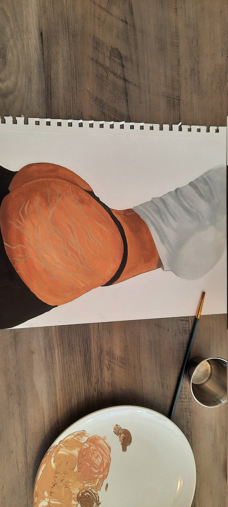 May include: A close-up of a painting on paper of a person's torso. The painting is done in shades of brown, black, and white. The person is wearing a white shirt and black underwear. A paint palette with brown paint is visible in the foreground.