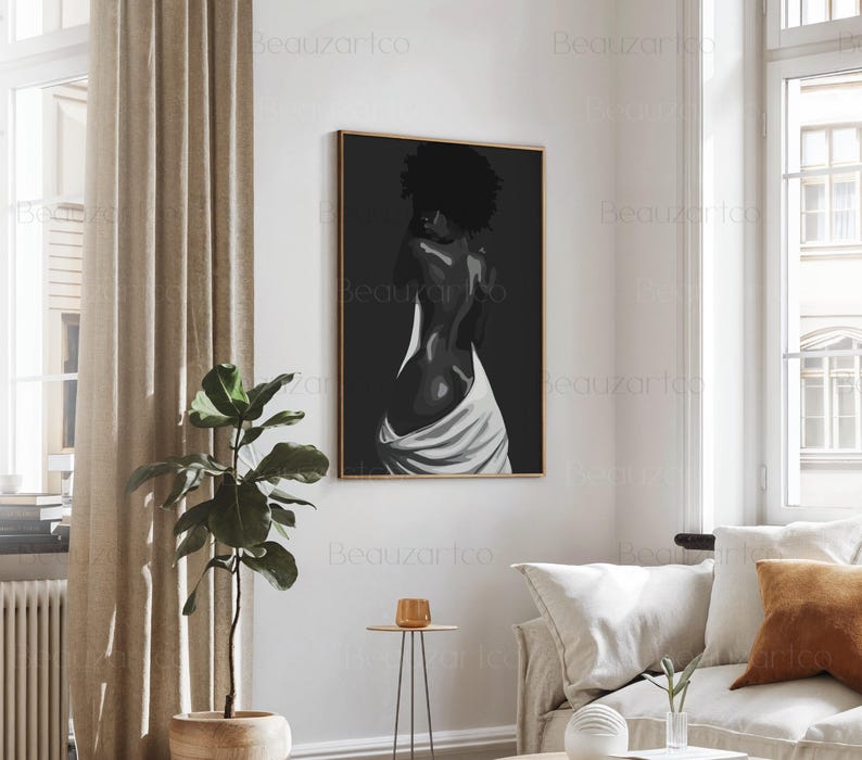 May include: Black and white painting of a person with their back to the viewer, wearing a white cloth draped around their waist. The painting is framed in a thin, gold frame.