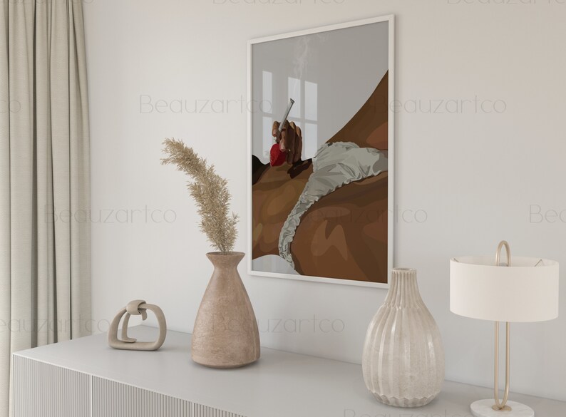 May include: A framed illustration of a person in a white and brown outfit, with a red accent, holding a cigarette. The illustration is set against a gray background with a window in the background.