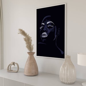 May include: A black and white illustration of a woman's face with dramatic makeup. The woman is looking up and her eyes are closed. The background is black.