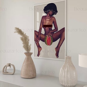 May include: A framed illustration of a woman with short, dark hair sitting with her legs spread, holding a watermelon in front of her.