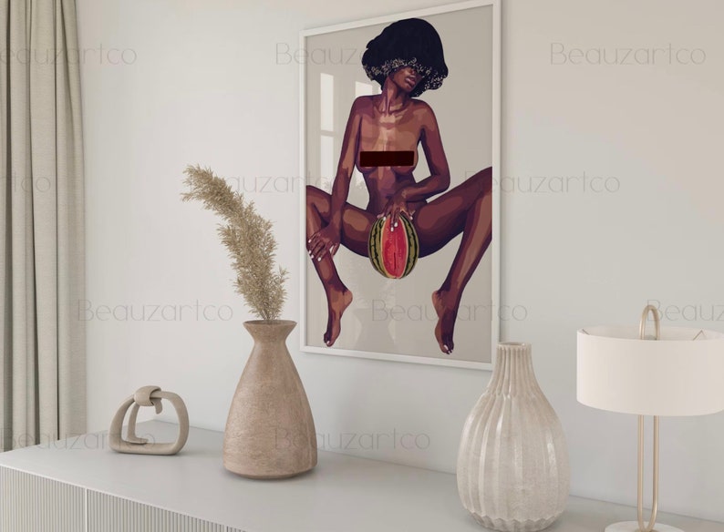 May include: A framed illustration of a woman with short, dark hair sitting with her legs spread, holding a watermelon in front of her.