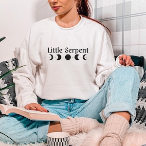 Sweatshirt Little Serpent, Serpent & the Wings of Night, Crowns of Nyaxia, boekmerchandise, maanstanden, Carissa Broadbent IK OFFICIEEL LICENTIE HEEFT