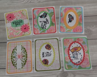 May include: Six handmade greeting cards with floral designs. Each card features a different design with butterflies, flowers, and other decorative elements. The cards are all blank inside for writing messages.