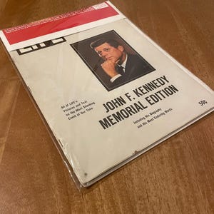 May include: A vintage LIFE magazine John F. Kennedy Memorial Edition with a portrait of the president. The cover features the text: All of LIFE's Pictures and Text on the Most Shocking Event of Our Time, Including His Biography and His Most Enduring Words, and 50 cents.