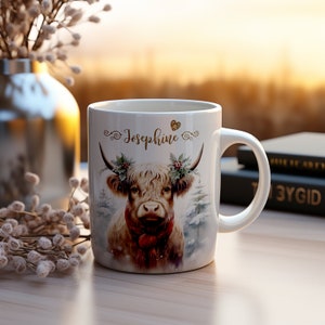 Keramik Tasse personalisiert, Highland Kuh mit Schal im Winter, dekoriert mit Hörner dekoriert mit Stechpalme, Tannen im Hintergrund
