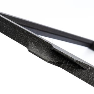 May include: Close-up of a black foam frame with a textured surface. The frame is made of a thick, durable material and has a simple, modern design.
