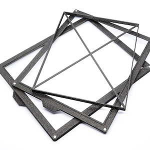 May include: Three black, rectangular frames are stacked on top of each other. The frames are made of a textured material and have a slightly raised edge.