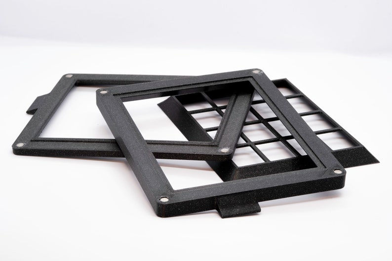May include: Three black plastic frames with a grid pattern. The frames are stacked on top of each other.