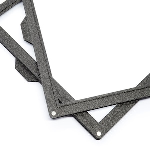 May include: Two black foam picture frames with a textured surface. The frames are overlapping and are angled to show the inside of the frames.