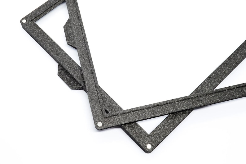 May include: Two black foam picture frames with a textured surface. The frames are overlapping and are angled to show the inside of the frames.