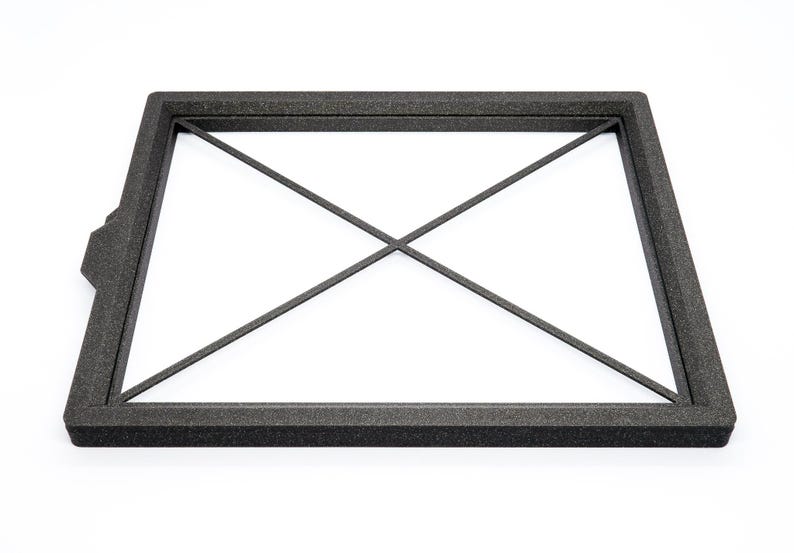 May include: Black foam frame with a criss-cross pattern inside. The frame is designed to protect a delicate object.