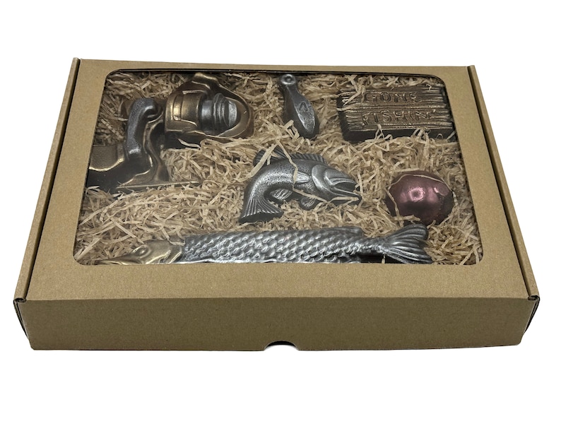 Peut inclure: Coffret cadeau avec fen&ecirc;tre transparente, rempli de paille et d'articles sur le th&egrave;me de la p&ecirc;che. Comprend un moulinet, un leurre, une bo&icirc;te en bois avec le texte "Gone Fishing", un poisson, un flotteur et un long poisson.