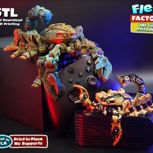 May include: A 3D-printed scorpion design in tan, blue, and orange, perched on a black game console. The image includes text that says '.STL Digital Download for 3D Printing' and 'Flexi Factory'. The design is made to be printed in PLA.