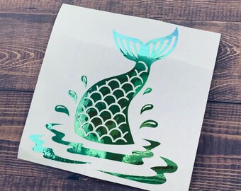 May include: Green and blue mermaid tail decal with scales and water splashes. The decal is on a white background.