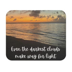 May include: A sunset over the ocean with the quote "Even the darkest clouds make way for light" on a dark background.