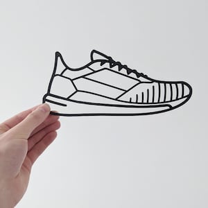 May include: Black and white line drawing of a running shoe. The shoe has a rounded toe, laces, and a textured sole.