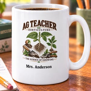May include: A white ceramic mug featuring the text AG TEACHER HORTICULTURE THE SCIENCE OF GROWING and Mrs. Anderson. The graphic includes illustrations of green plants with visible roots, a small hand trowel, and pruning shears in brown and silver.