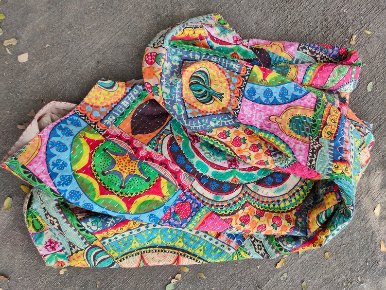 Puede incluir: Una colcha de retazos colorida con una variedad de patrones y dise&ntilde;os, incluyendo c&iacute;rculos, flores y formas geom&eacute;tricas. La colcha est&aacute; hecha de tela de algod&oacute;n y est&aacute; cosida a mano.