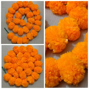 May include: A garland of bright orange marigold flowers, made of tissue paper, is arranged in a circle. The garland is perfect for decorating for a festival or special occasion.