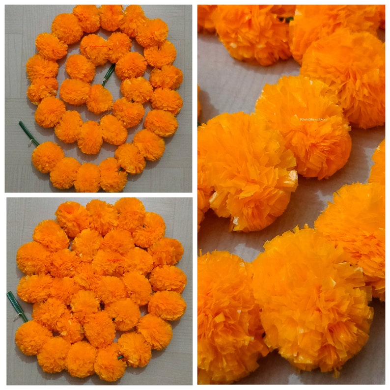 May include: A garland of bright orange marigold flowers, made of tissue paper, is arranged in a circle. The garland is perfect for decorating for a festival or special occasion.