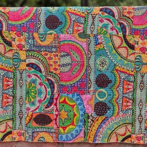 Könnte beinhalten: Ein farbenfroher Patchwork-Deckenbezug mit verschiedenen floralen und geometrischen Mustern in den Farben Rosa, Blau, Grün, Gelb und Orange. Der Bezug ist aus Baumwollstoff und hat eine gesteppte Textur.