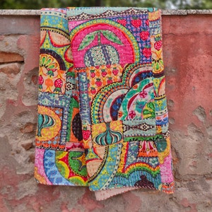 Puede incluir: Una colcha de retazos colorida con una variedad de patrones y dise&ntilde;os, incluyendo motivos florales, formas geom&eacute;tricas y patrones paisley. La colcha est&aacute; hecha de tela de algod&oacute;n y est&aacute; cosida a mano.
