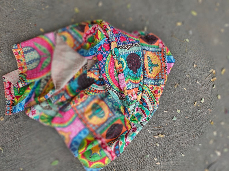 Puede incluir: Una colcha kantha colorida con un dise&ntilde;o de patchwork que presenta varias formas geom&eacute;tricas, patrones florales y p&aacute;jaros. La colcha est&aacute; hecha de algod&oacute;n y tiene un tacto suave y texturizado.