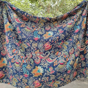 K&ouml;nnte beinhalten: Eine blaue Kantha-Steppdecke mit einem floralen Muster in Rosa-, Gelb- und Gr&uuml;nt&ouml;nen. Die Steppdecke ist aus Baumwolle und hat ein handgesticktes Design.