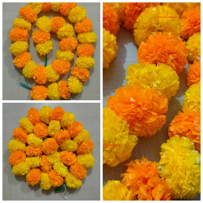 May include: A garland of yellow and orange marigold flowers, made of paper, for decoration. The garland is strung together with a green thread.