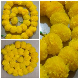 May include: A garland of yellow marigold flowers, made of fabric, is arranged in a circle. The garland is perfect for decorating for a special occasion or festival.
