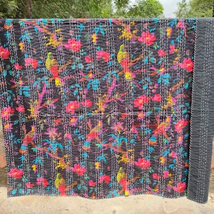 May include: Black kantha quilt with a floral and bird pattern. The quilt is made of cotton and has a hand-stitched design.