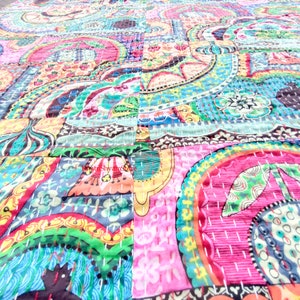 Puede incluir: Una colcha de retazos colorida con un patr&oacute;n de paisley. La colcha est&aacute; hecha de varias telas en tonos de rosa, azul, verde y amarillo. La colcha est&aacute; cosida a mano y tiene un estilo &uacute;nico y bohemio.