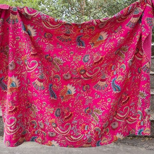 K&ouml;nnte beinhalten: Eine rosafarbene Kantha-Steppdecke mit floralem und Paisley-Muster. Die Decke ist aus Baumwolle und handgen&auml;ht.