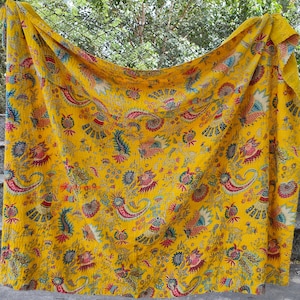 K&ouml;nnte beinhalten: Eine gelbe Kantha-Steppdecke mit einem floralen und Paisley-Muster in Rot-, Blau- und Gr&uuml;nt&ouml;nen.